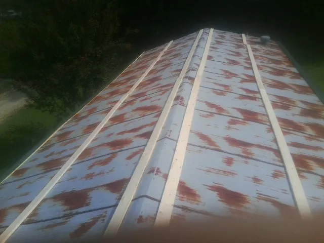 Rusted metal roof panels with new wood purlins before replacement — Storm Damage Roof Repair in Exmore by Roofing Brothers