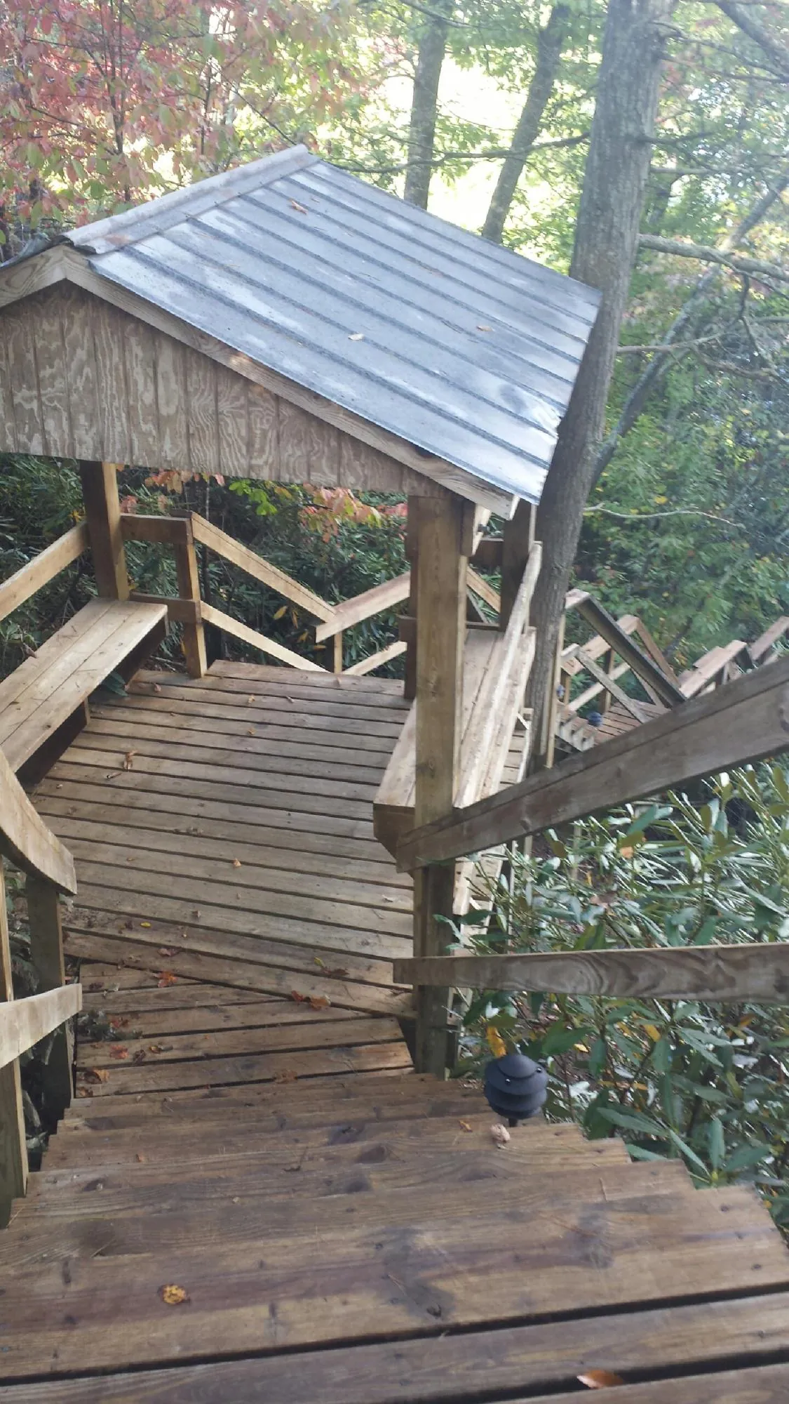 Metal roofed shelter over wooden steps on a wooded walkway — Skylight Repair & Installation work by our crew in Exmore