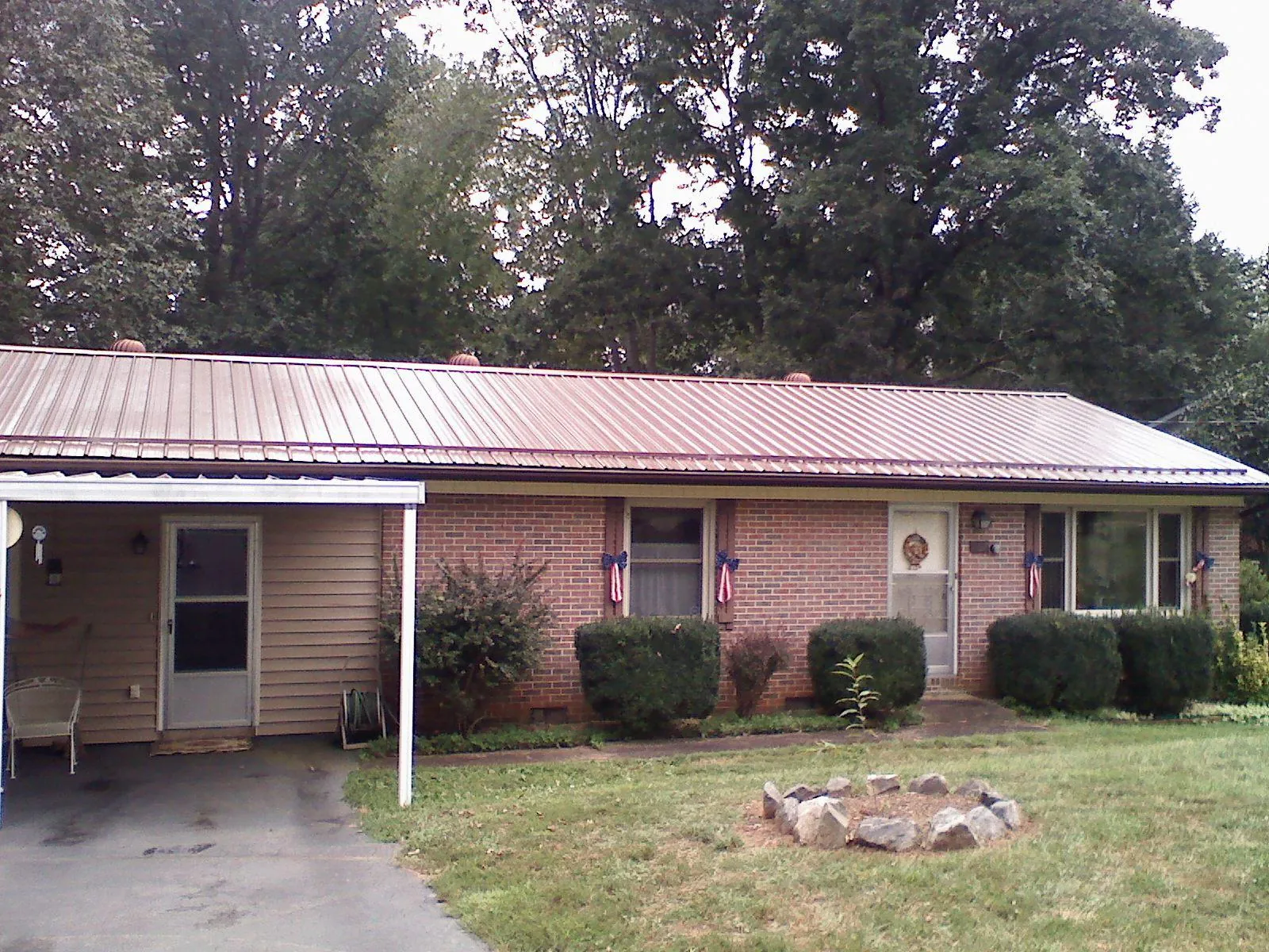 Bronze metal roof and carport on a brick ranch home — Roof Repair work by our crew in Exmore